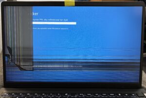 Jak sprawdzić model uszkodzonej matrycy w laptopie – rozbity ekran na stole serwisowym.